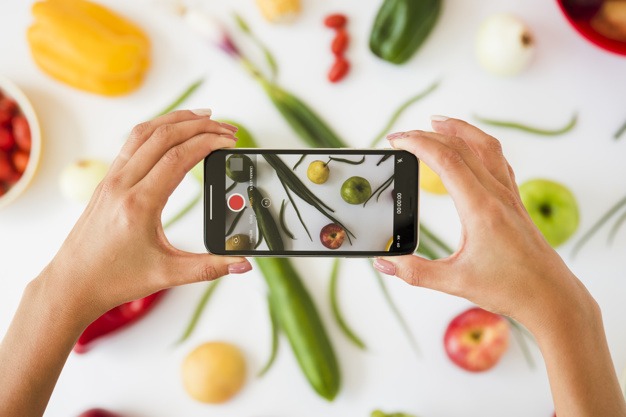 person taking photos of vegetables